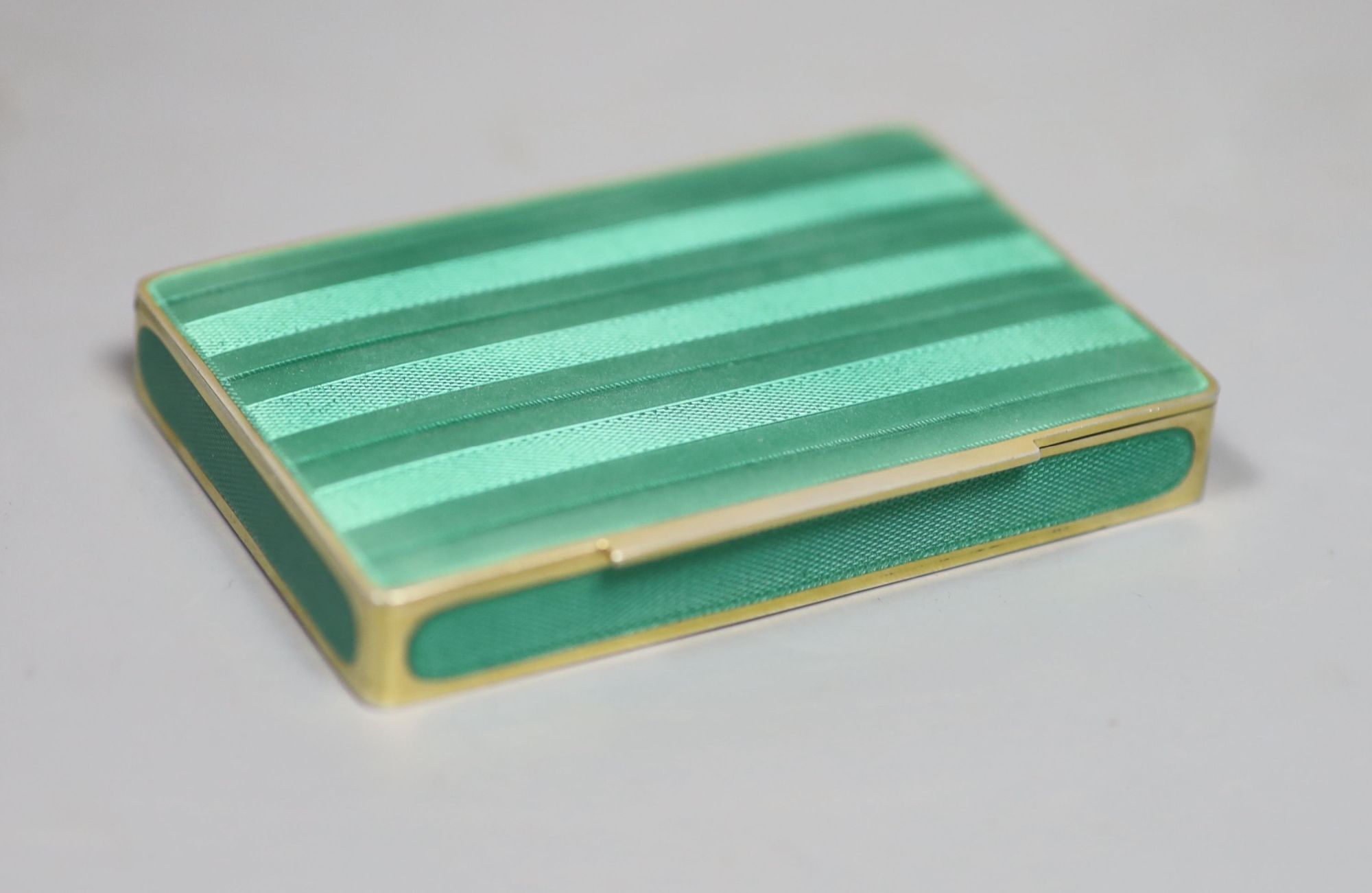 A cased early 20th century Austrian? gilt sterling and green enamelled silver gilt rectangular snuff box, 80mm, gross 122 grams,